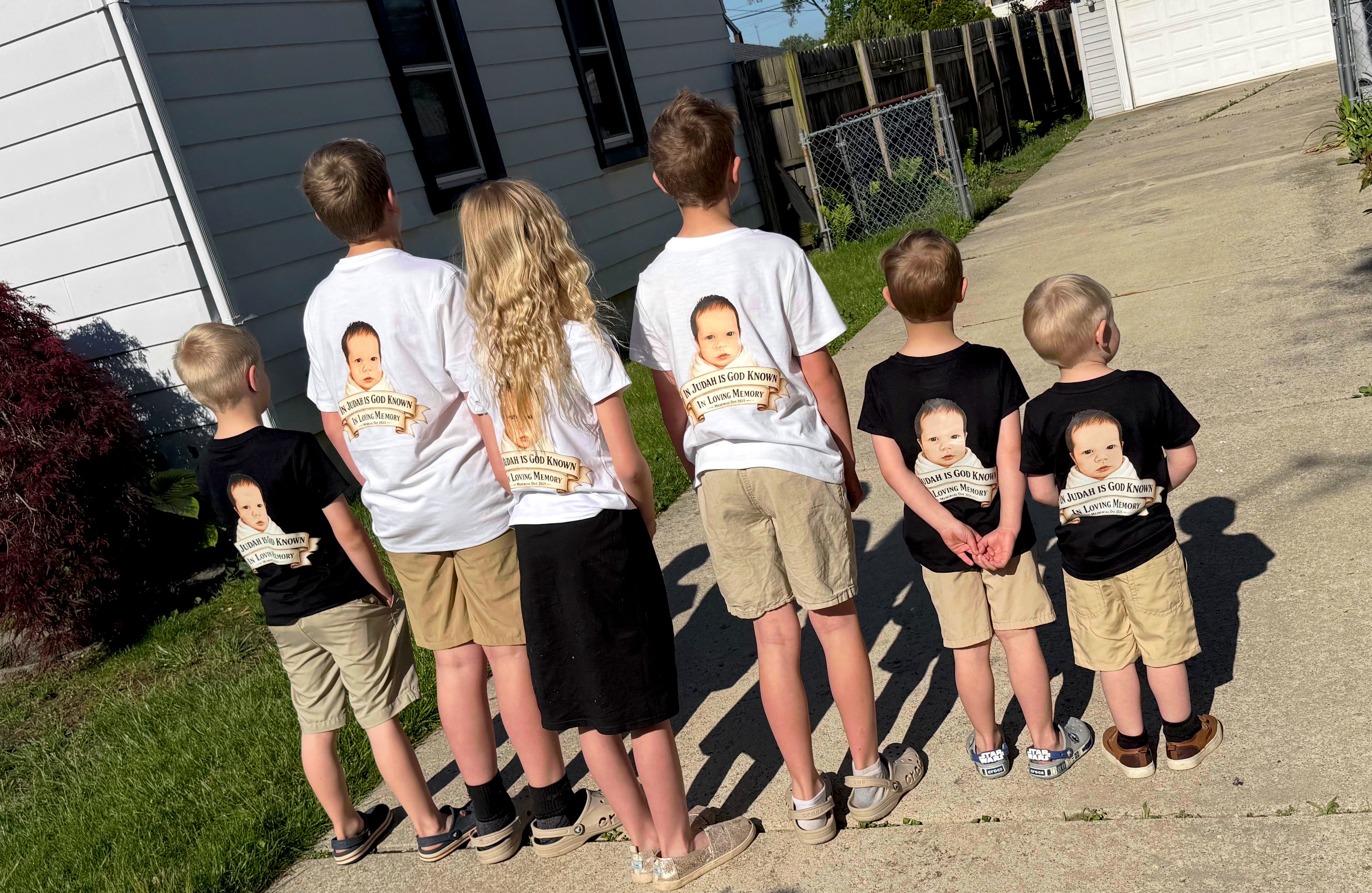 Judah's siblings wearing 'In Judah Is God Known' memorial shirts, one year later